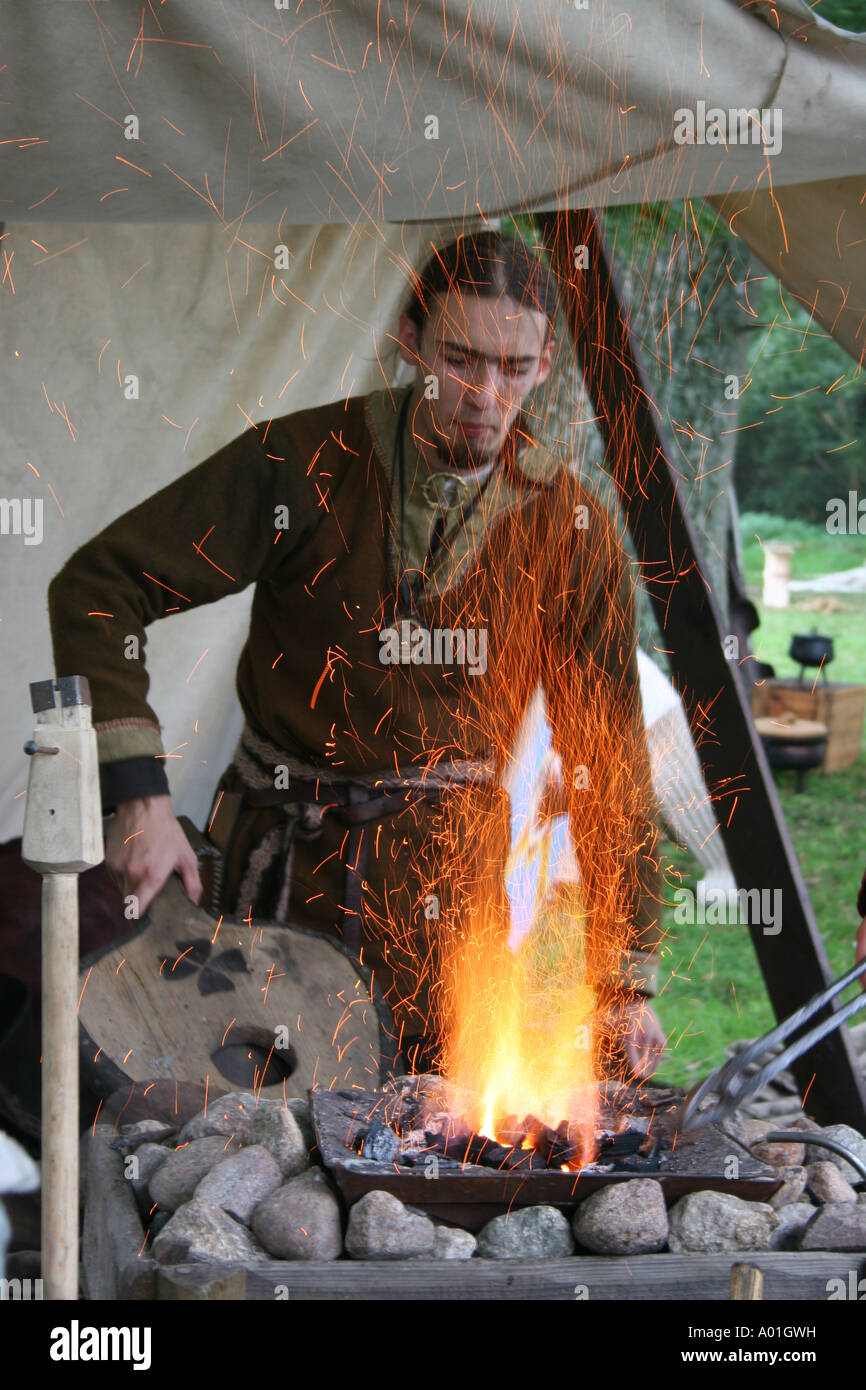A Saxon using bellows to light a fire. Stock Photo