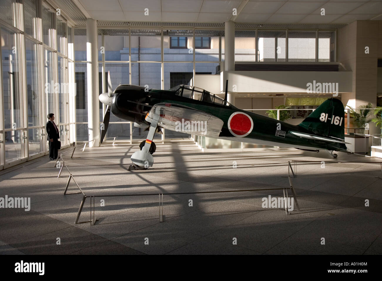 man looking at zero aircraft at the yasukuni shrine museum in Tokyo Japan Stock Photo