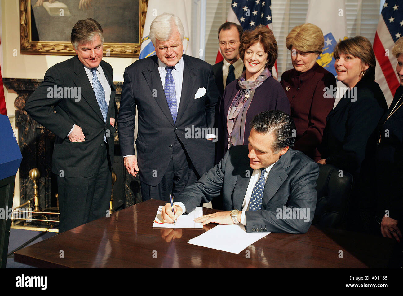 Senator Ted Kennedy watches as Governor Mitt Romney signs a bill into law Stock Photo