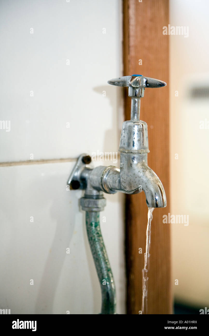 Old chrome tap dripping water causing waste and water shortages Stock
