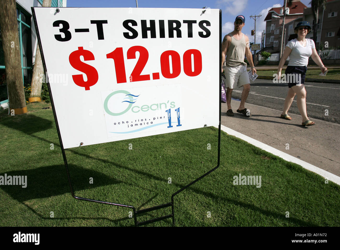 Cruise ship tourists pass a t-shirt advertisement in Ocho Rios Stock Photo