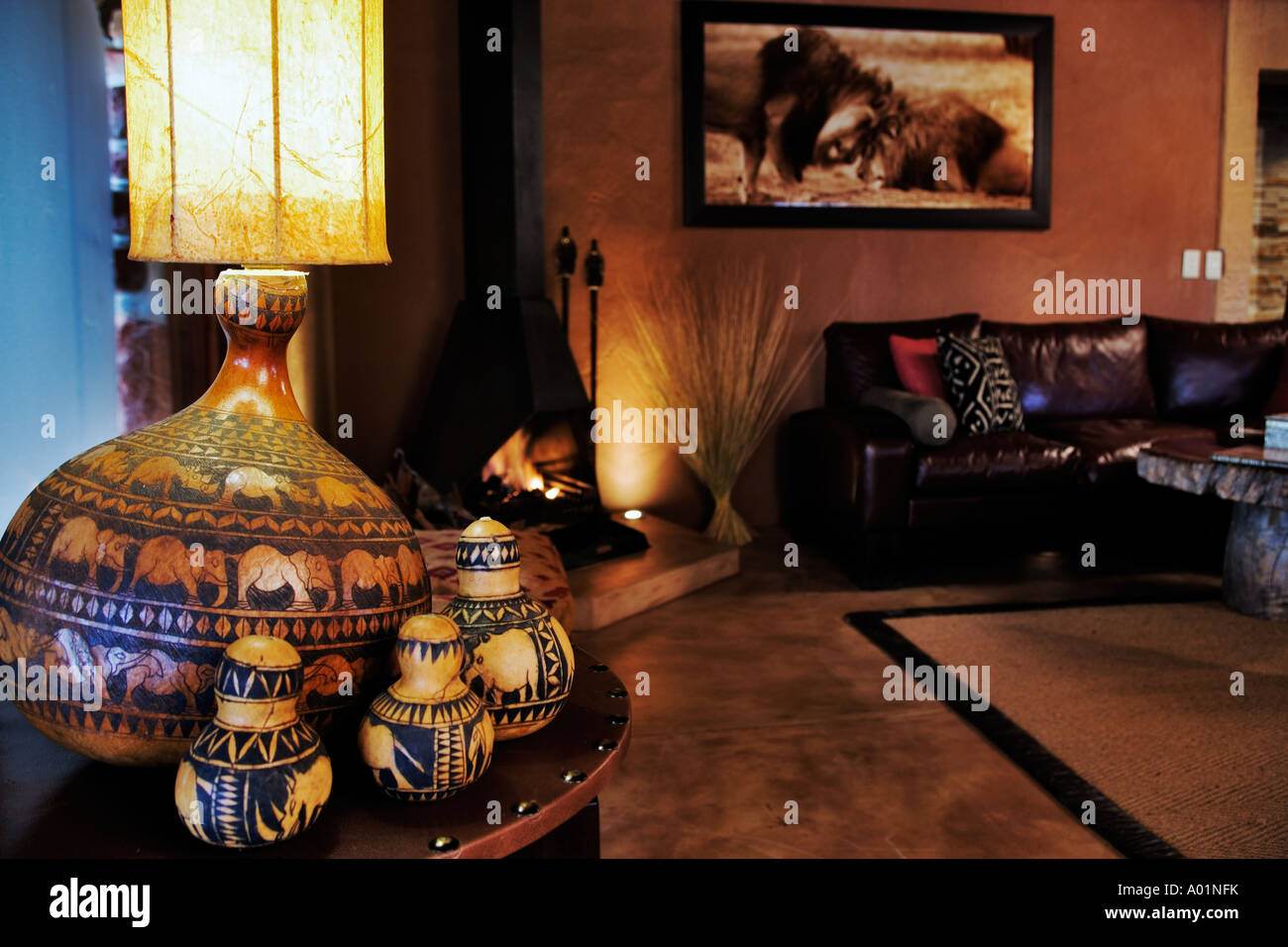 A cosy lounge with a rustic fireplace at the Villa a luxury lodge in Okonjima Private Game Reserve Namibia Stock Photo