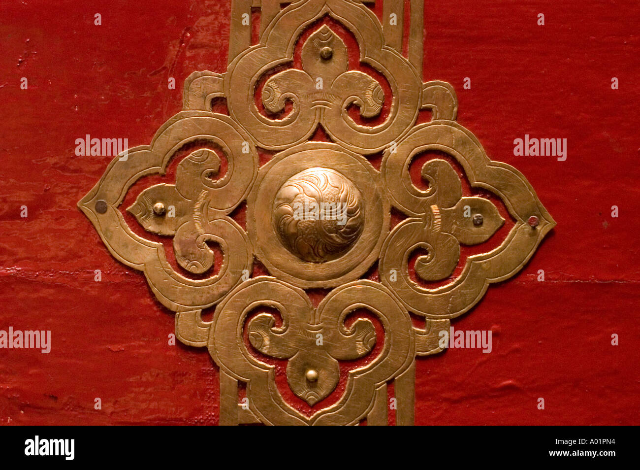 Metal door ornament with red backround in Sankar monastery Leh Ladakh
