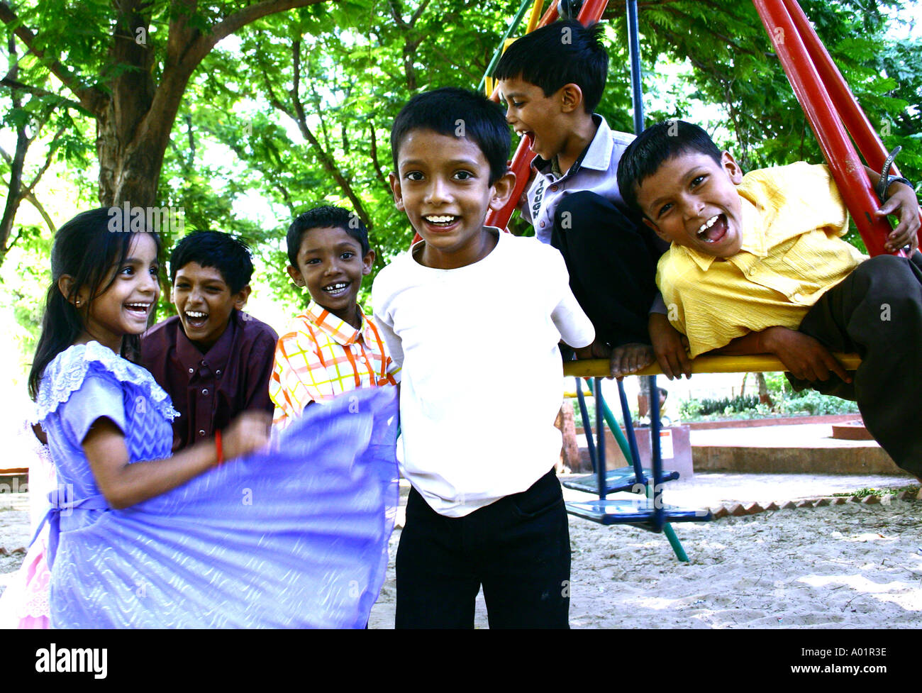 RSC0486 Children smiling and laughing and enjoying near a swing in park Gandhi Nagar Gujarat India Stock Photo