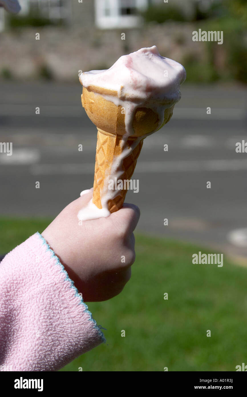 child's hand hold melting ice cream cone Stock Photo