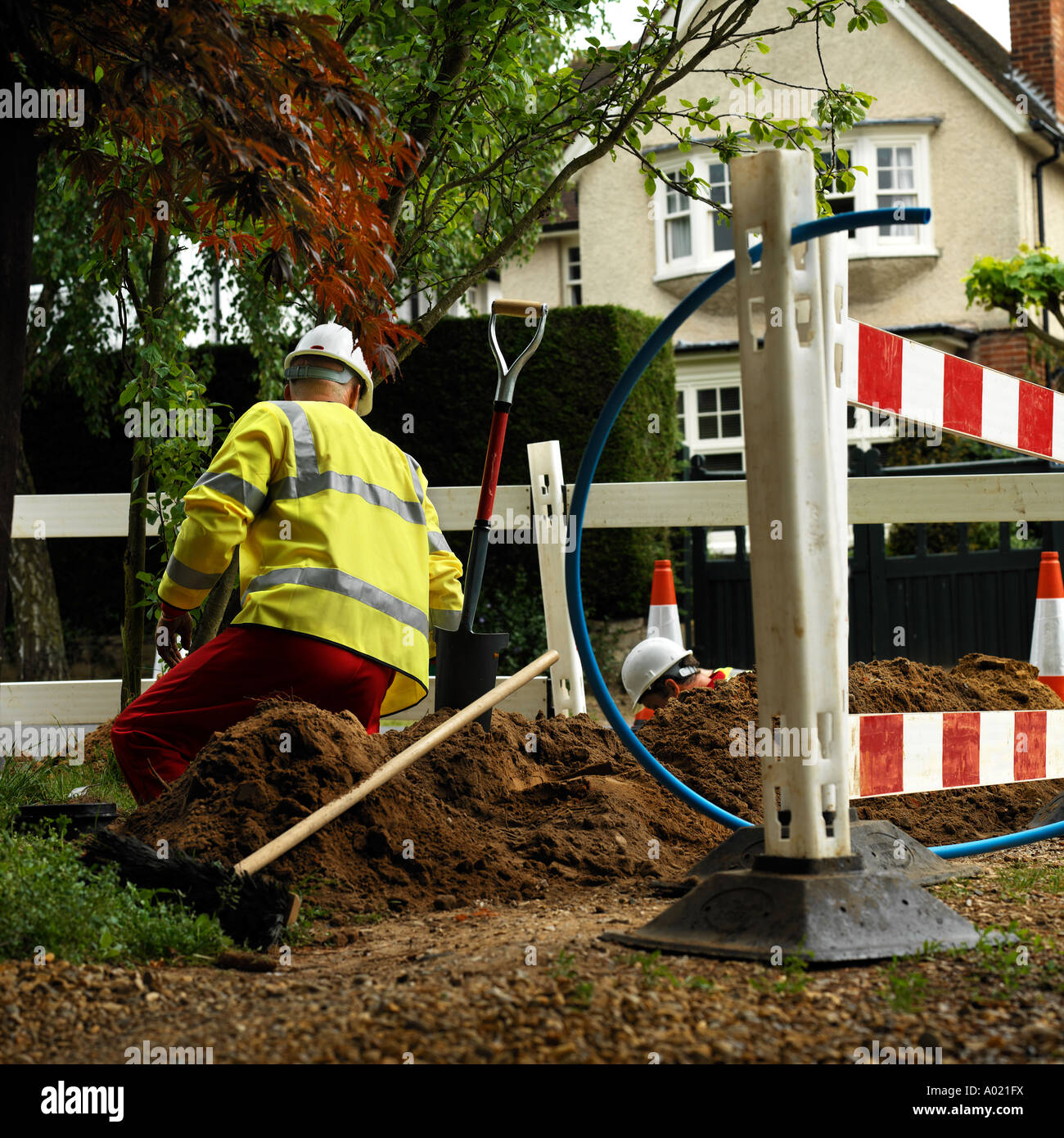 Water engineer digging hole England. No release required.as back view means man is unrecognizable Stock Photo