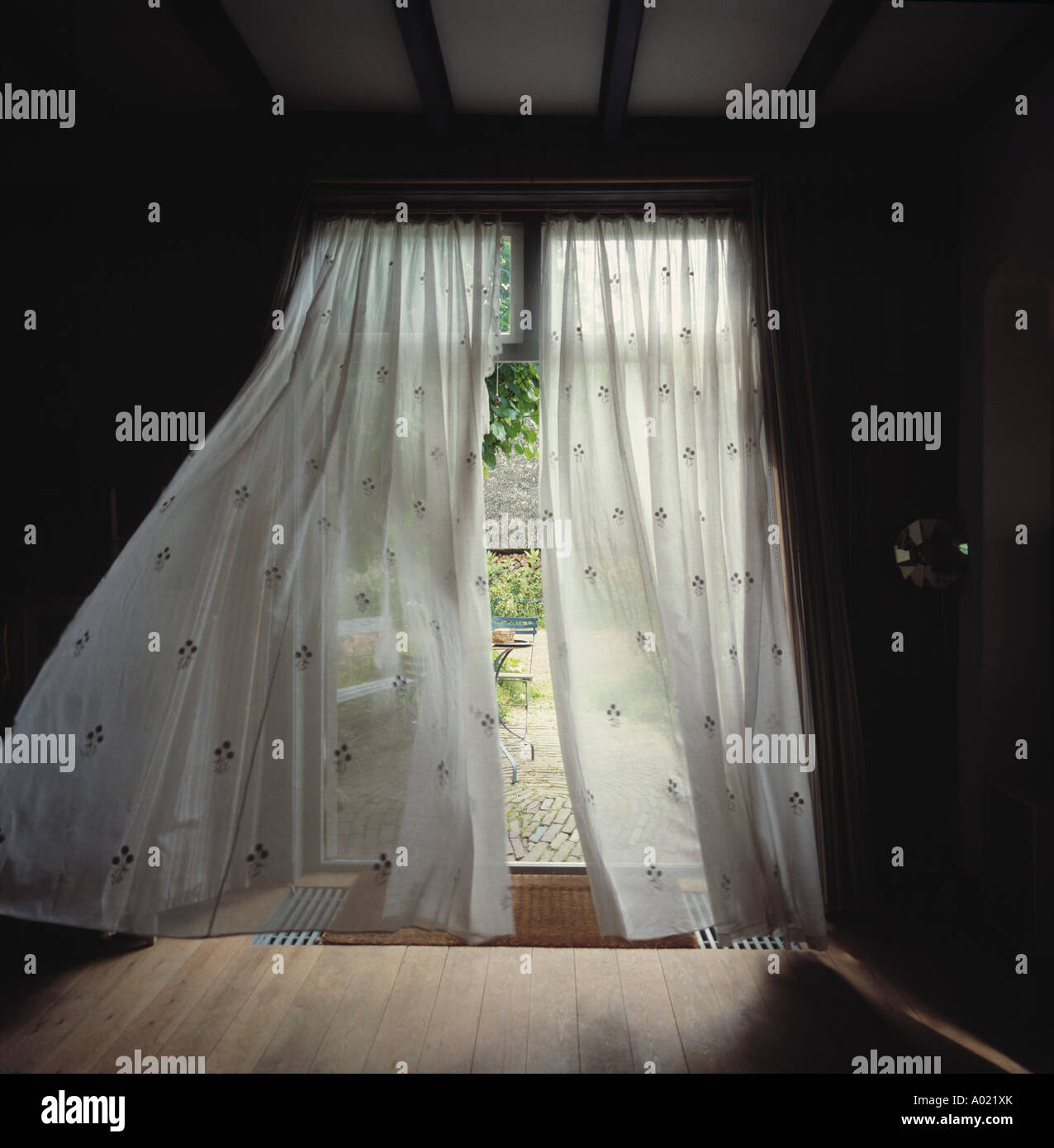 French doors with white voile curtains blowing in the wind Stock Photo -  Alamy