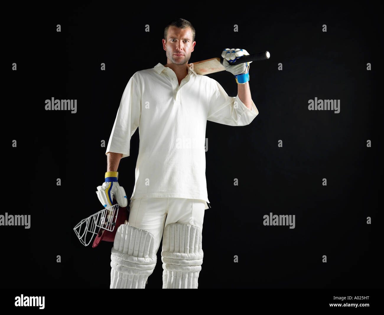 Cricket player, standing holding cricket bat on shoulder Stock Photo