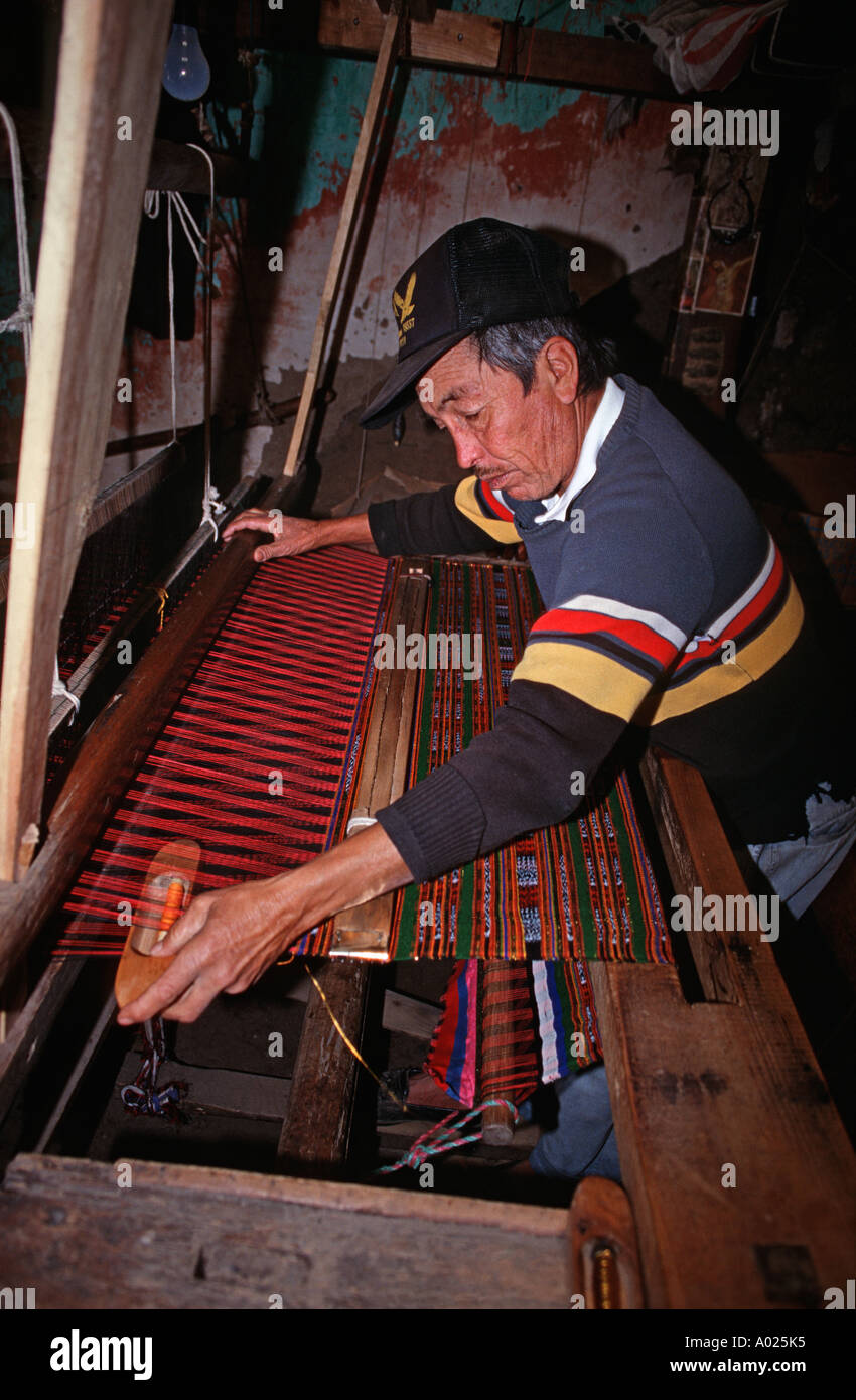 Maya man from San Cristobal Totonicapan sitting weaving at a treadle operated loom Guatemala Guatemalan weaver Stock Photo