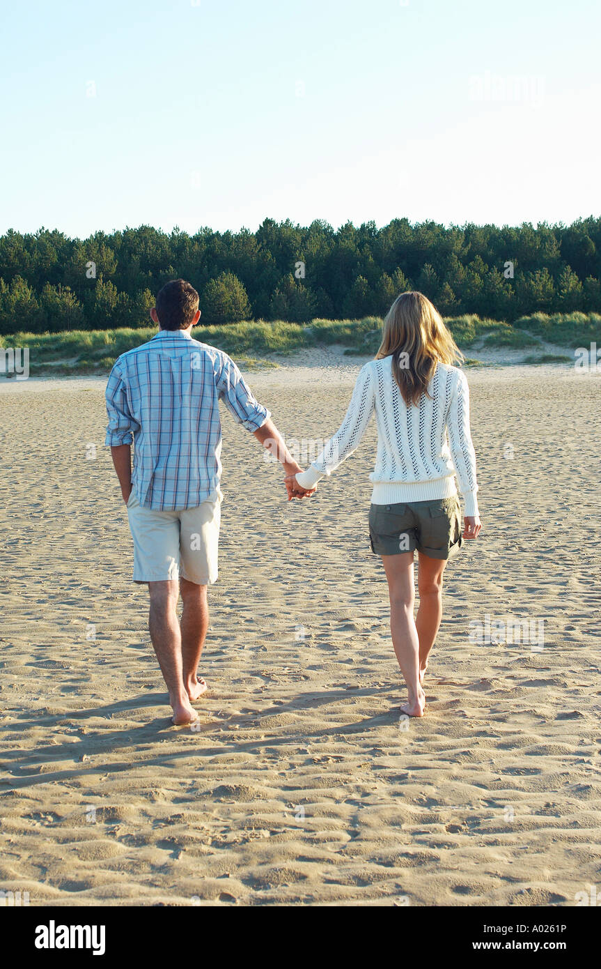 Couple Walking on Beach holding hands, back view Stock Photo - Alamy