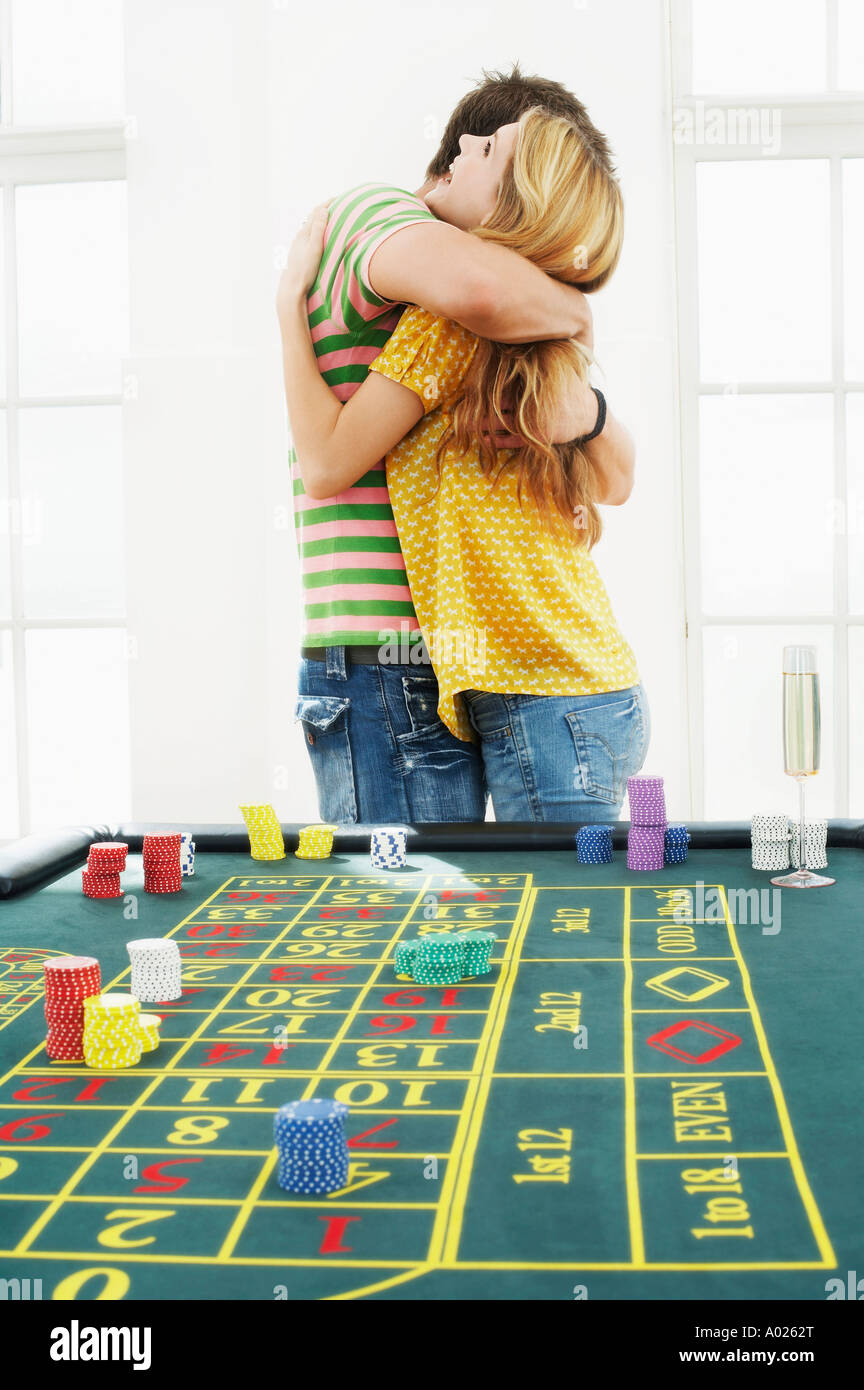 Young man hugging woman at roulette table Stock Photo