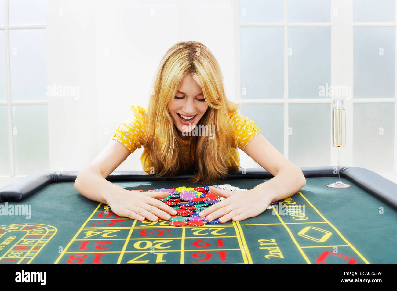 Happy woman at roulette table collecting chips Stock Photo