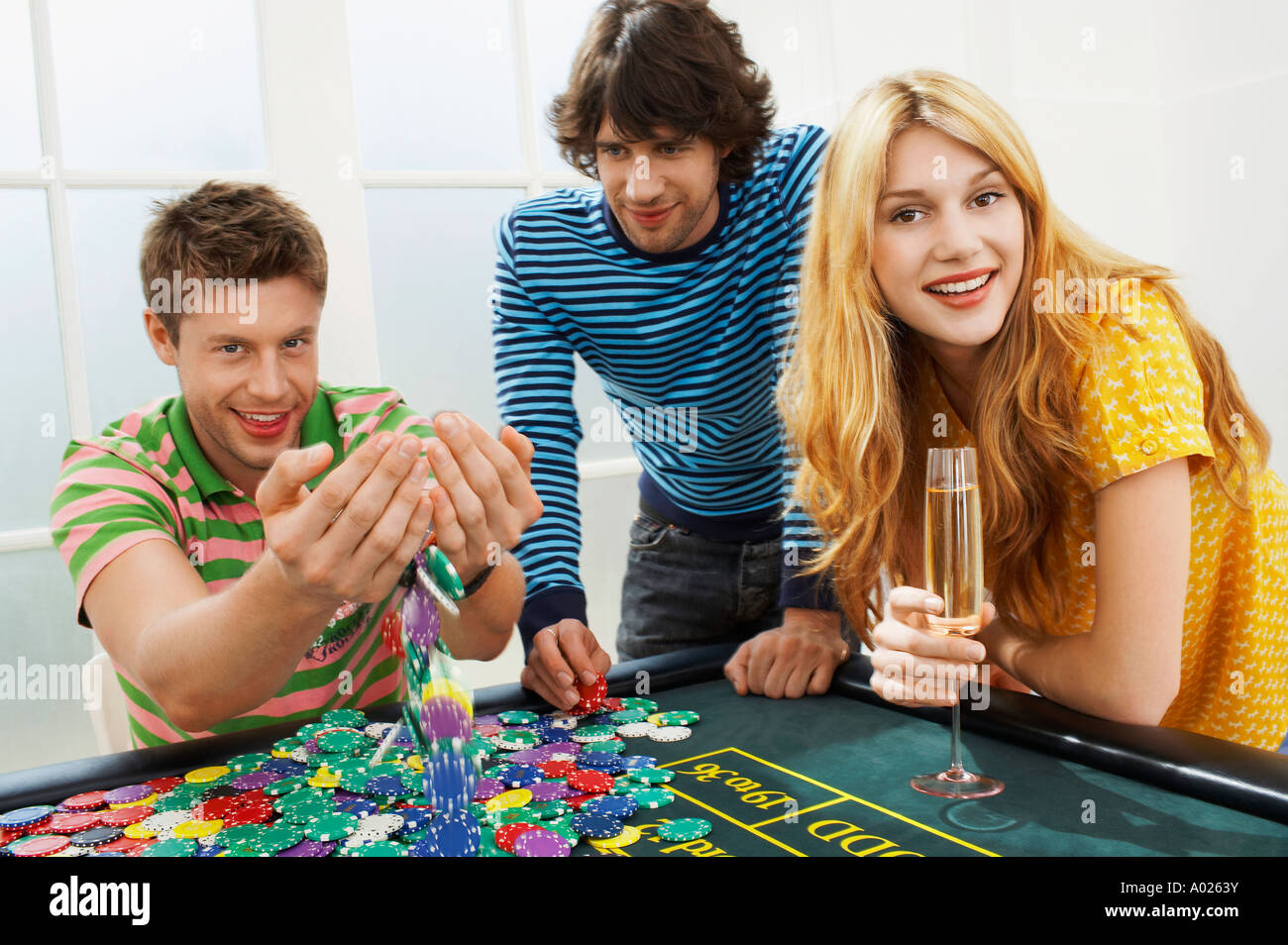 Young man with friends at roulette table playing with chips, portrait Stock Photo