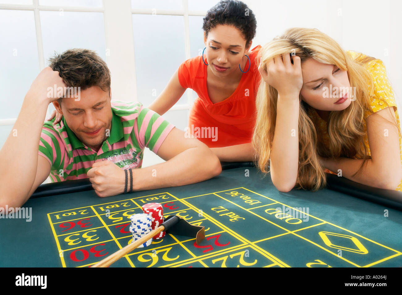 Young man at roulette table losing large bet Stock Photo