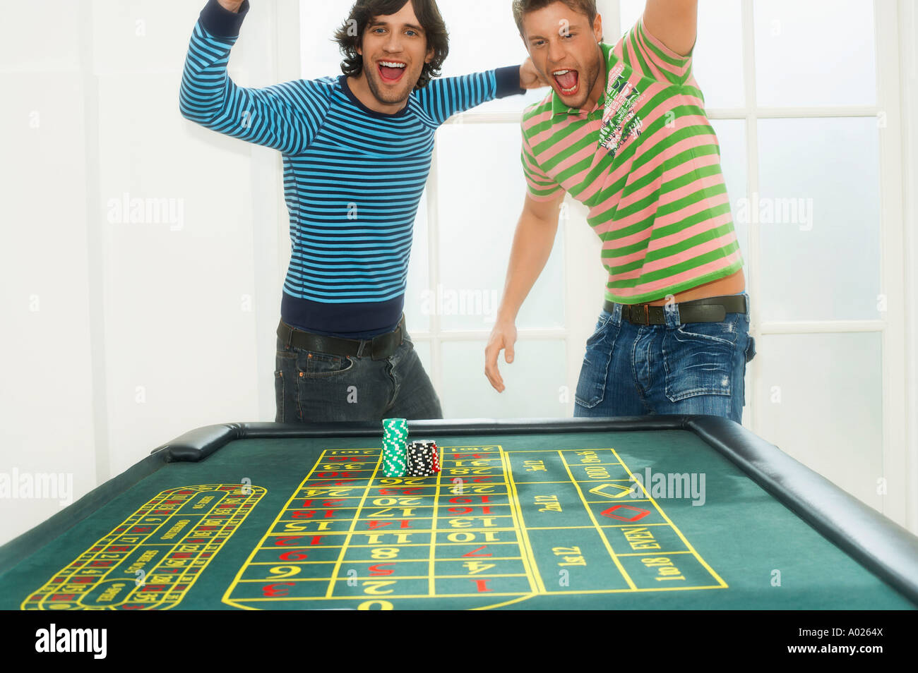 Two young men celebrating on roulette table, portrait Stock Photo