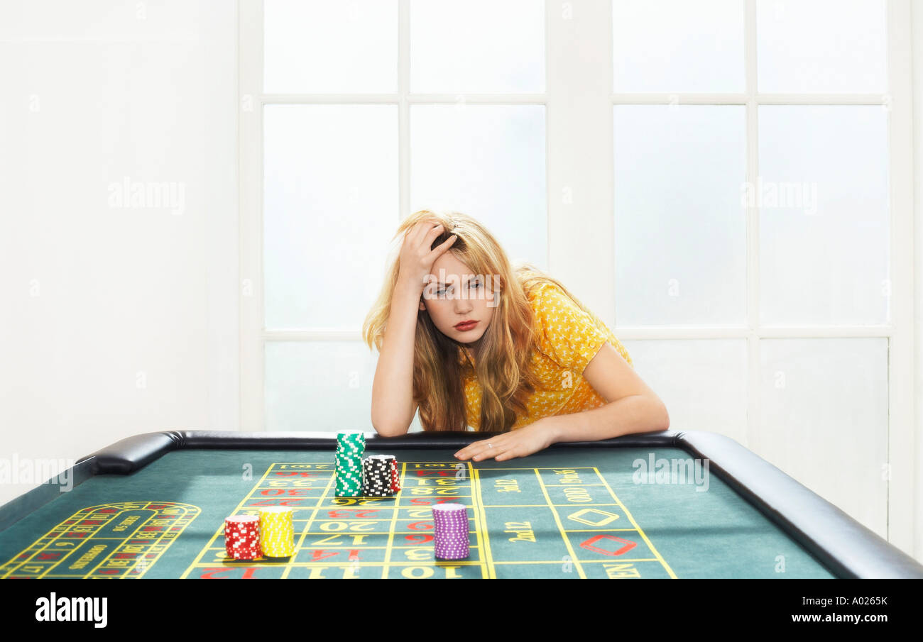 Young woman losing on roulette table Stock Photo