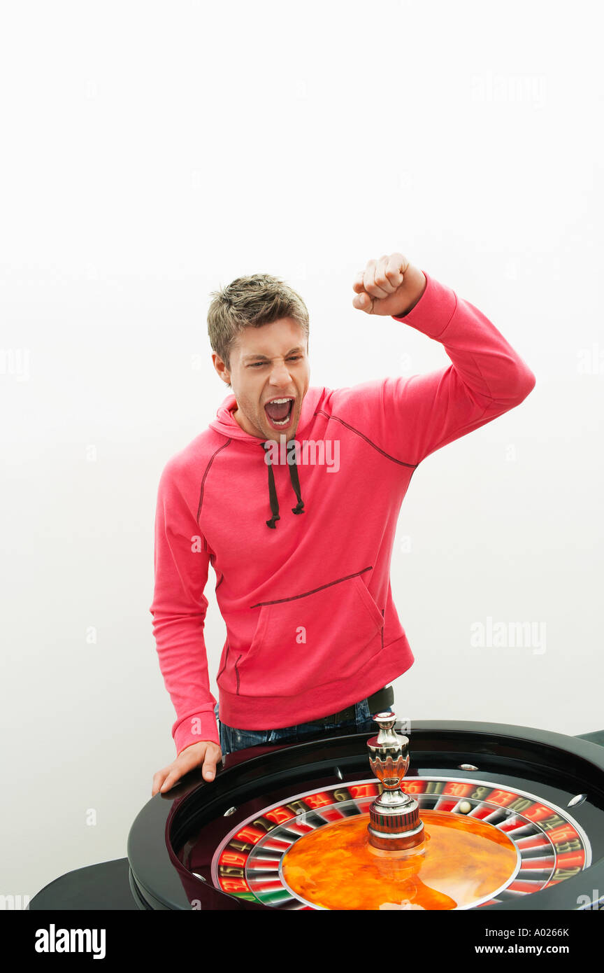Young Man celebrating at roulette wheel Stock Photo