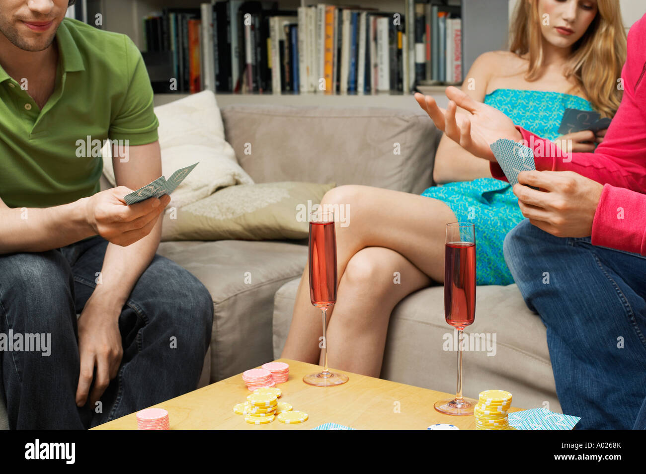 Friends Playing Cards in living room, mid section Stock Photo