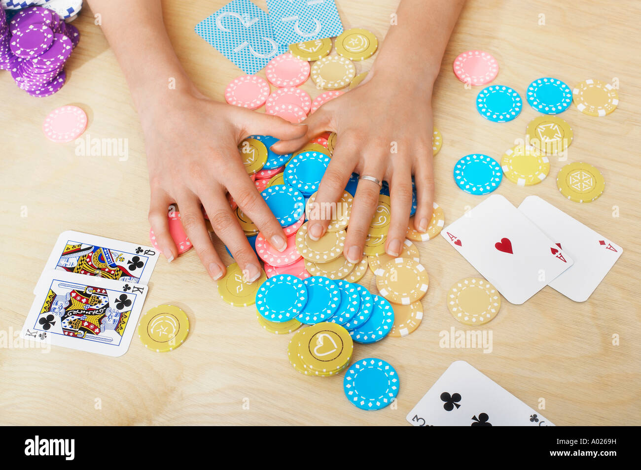 Hands of woman Grabbing Gambling Chips on table, close up of hands, overhead view Stock Photo