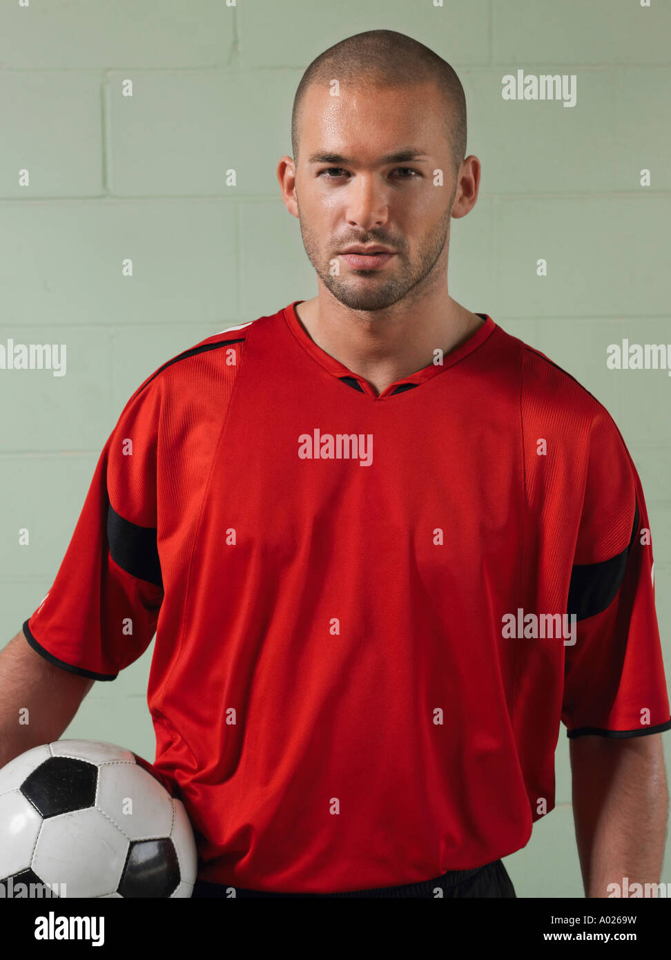 Soccer player holding ball, portrait Stock Photo