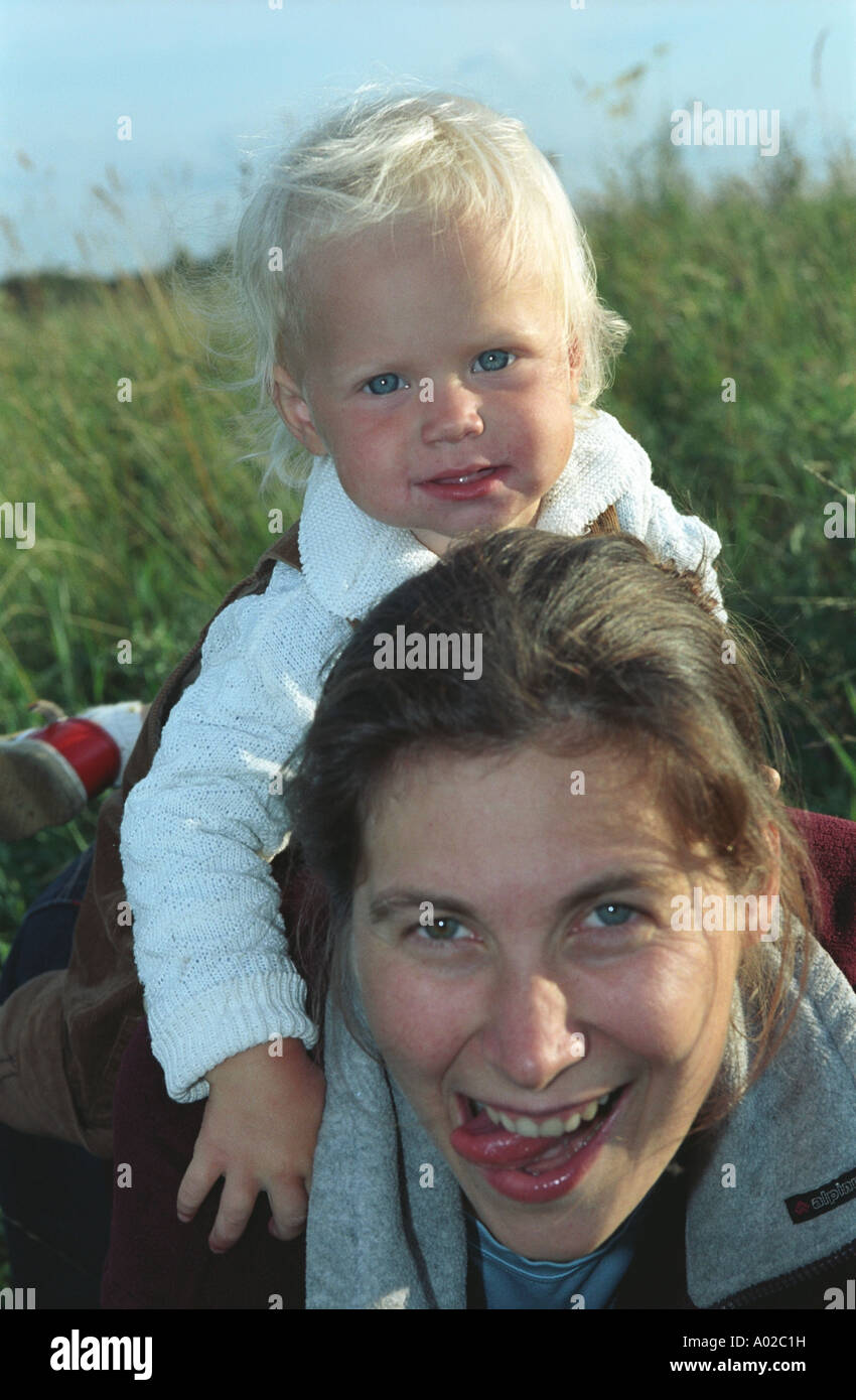 Girl riding on mother’s back. Altai. Siberia. Russia Stock Photo