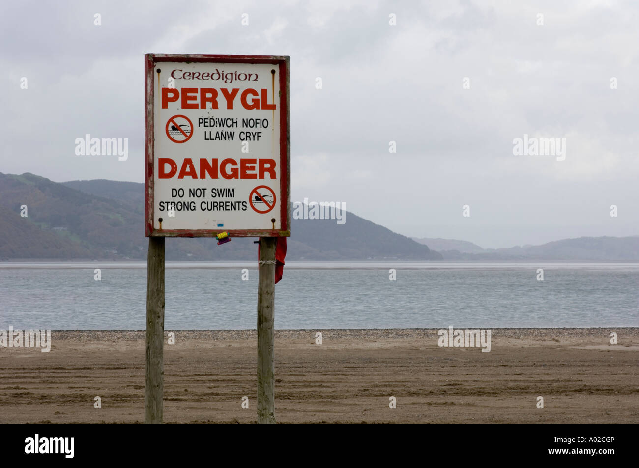 Perygl Danger bilingual welsh english sign warning of dangerous swimming conditions Ynyslas wales UK, Dyfi Estuary and river Stock Photo