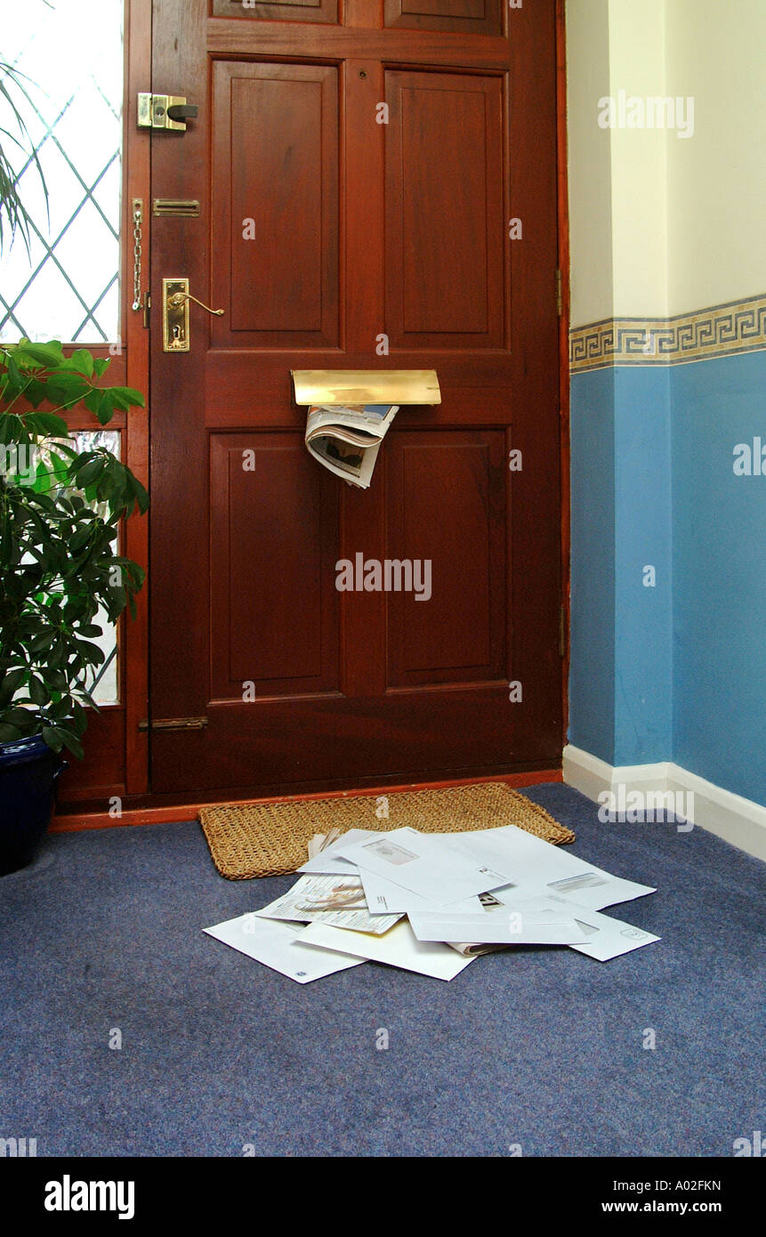 Mail building up inside the front door of a house when home owners are away on holiday. Stock Photo