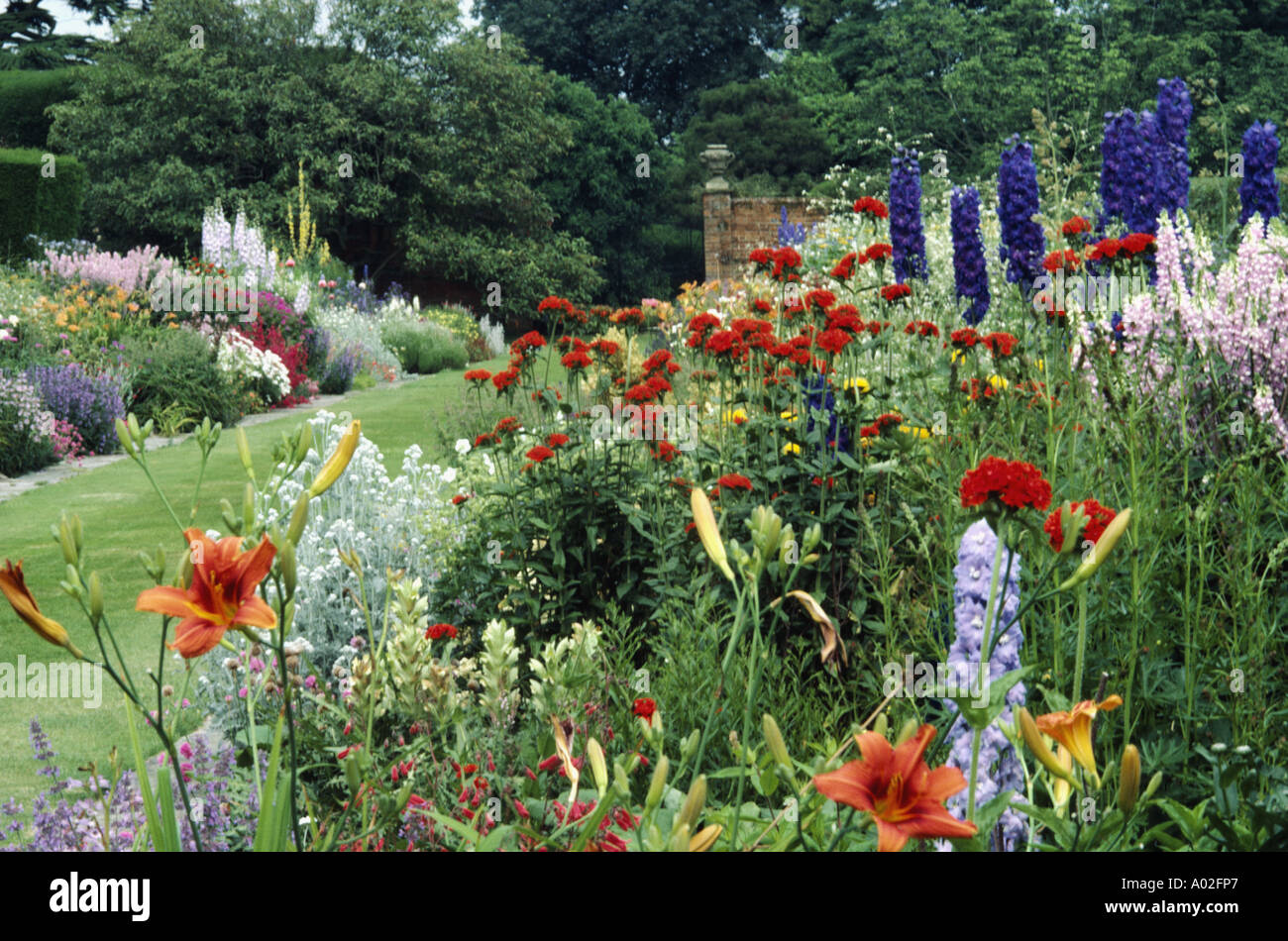 Double perennial borders in high summer with lilies delphiniums and scarlet catchfly Stock Photo
