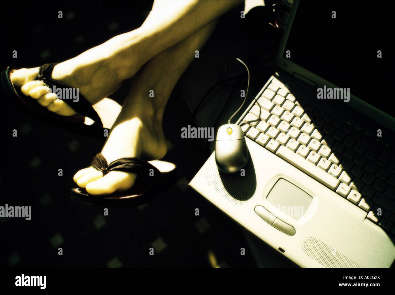 A person relaxing near the laptop computer Stock Photo