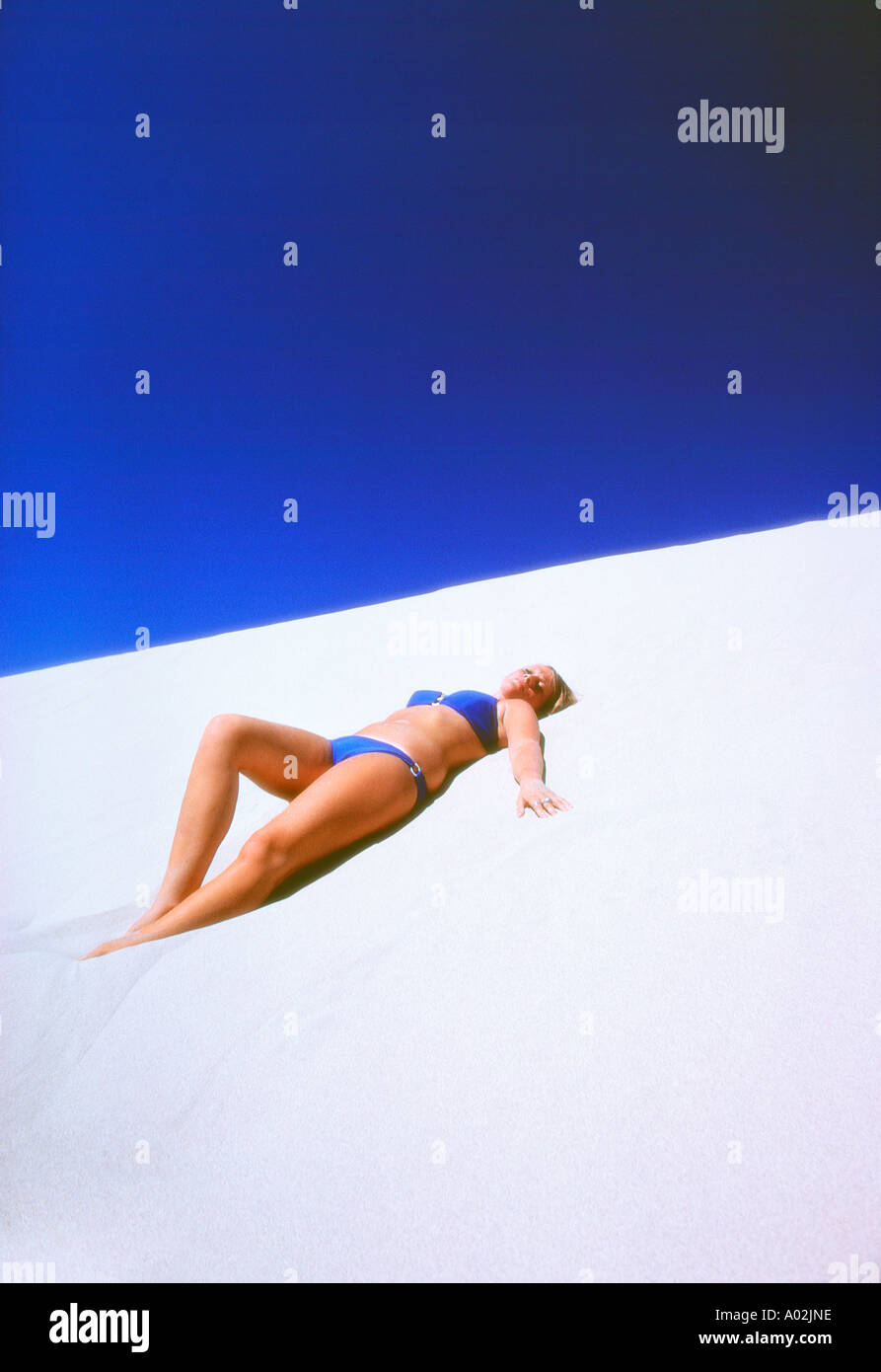 Caucasian woman sunbathing on beach Stock Photo