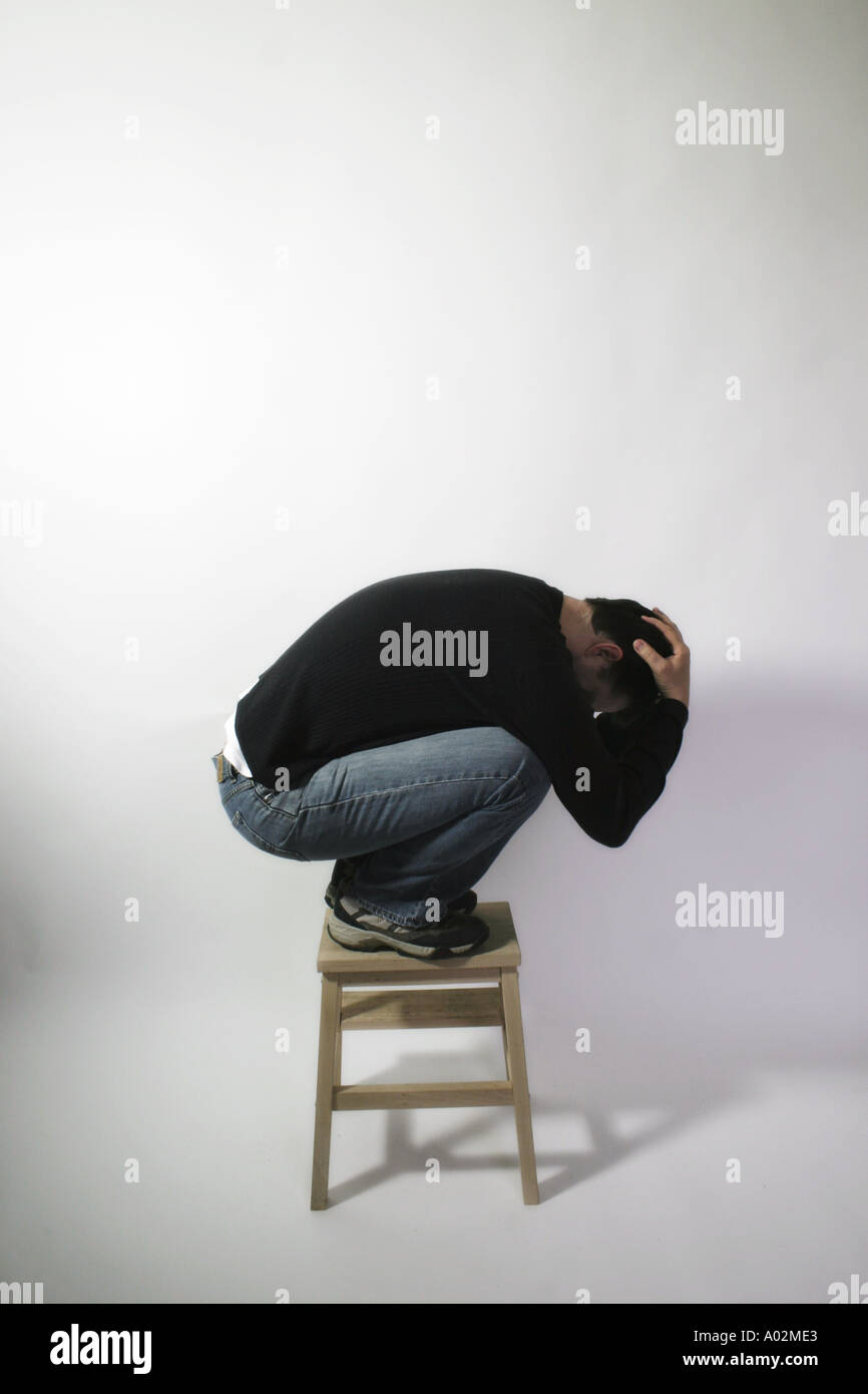 Side view or profile of man stood on stool and curled up into a ball Stock  Photo - Alamy