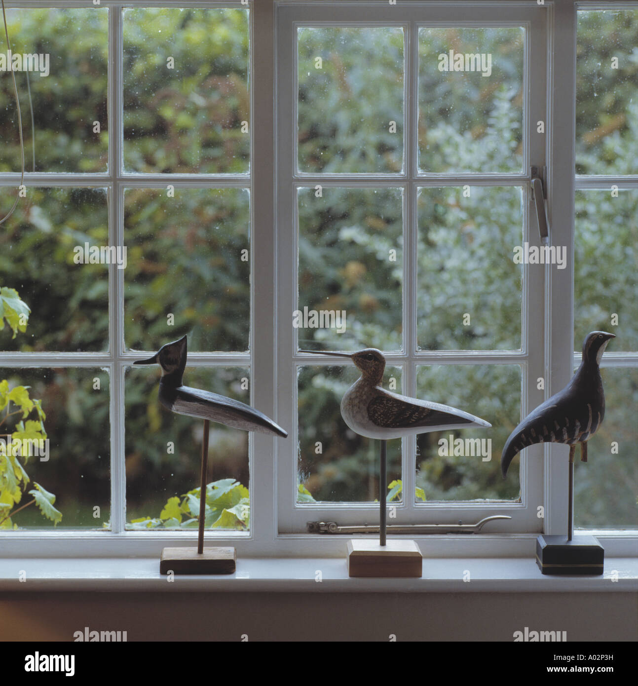 Close-up of carved wooden decoy birds on windowsill Stock Photo