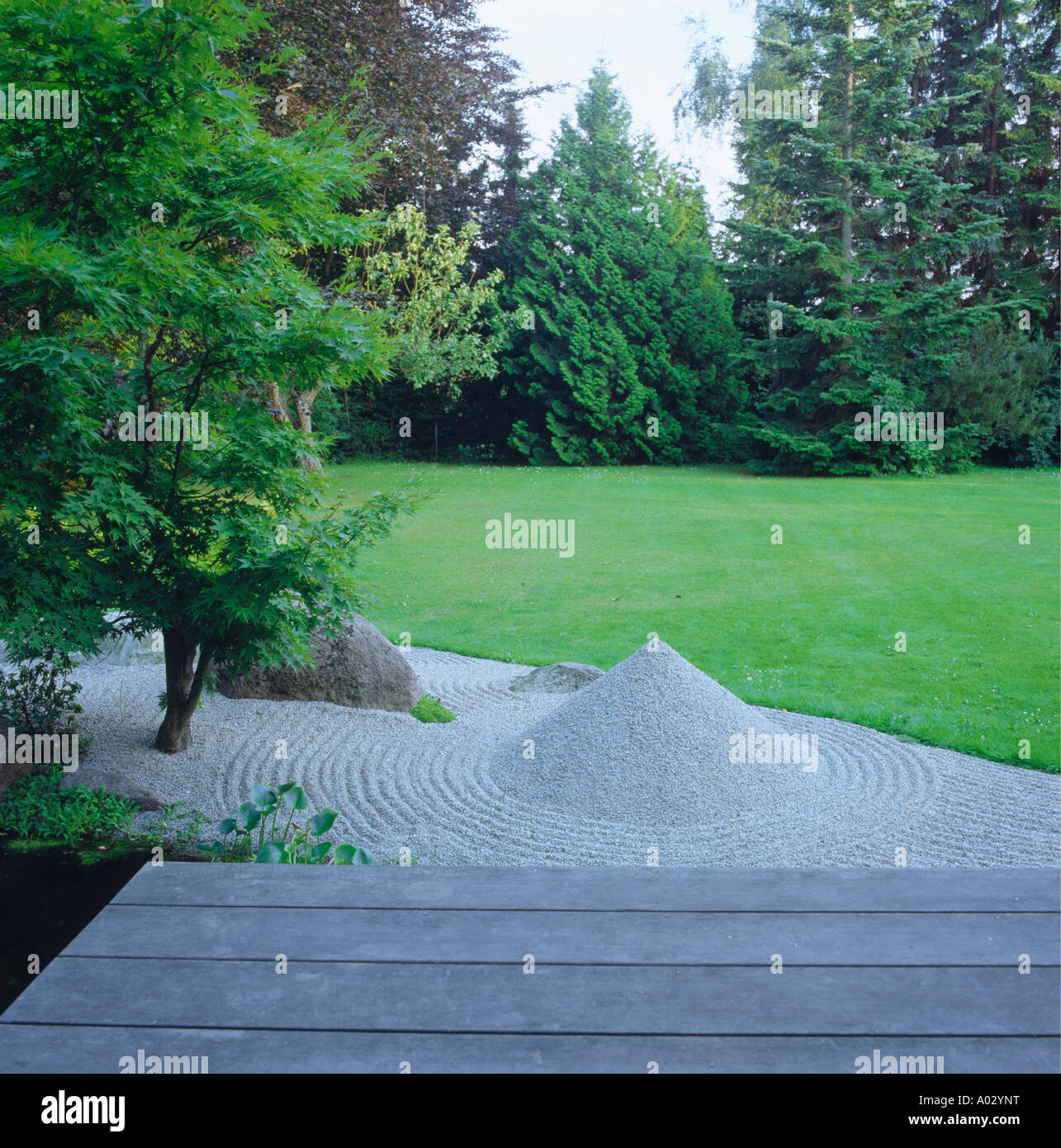 Raked gravel and sculpture in Zen garden with lawn Stock Photo Alamy