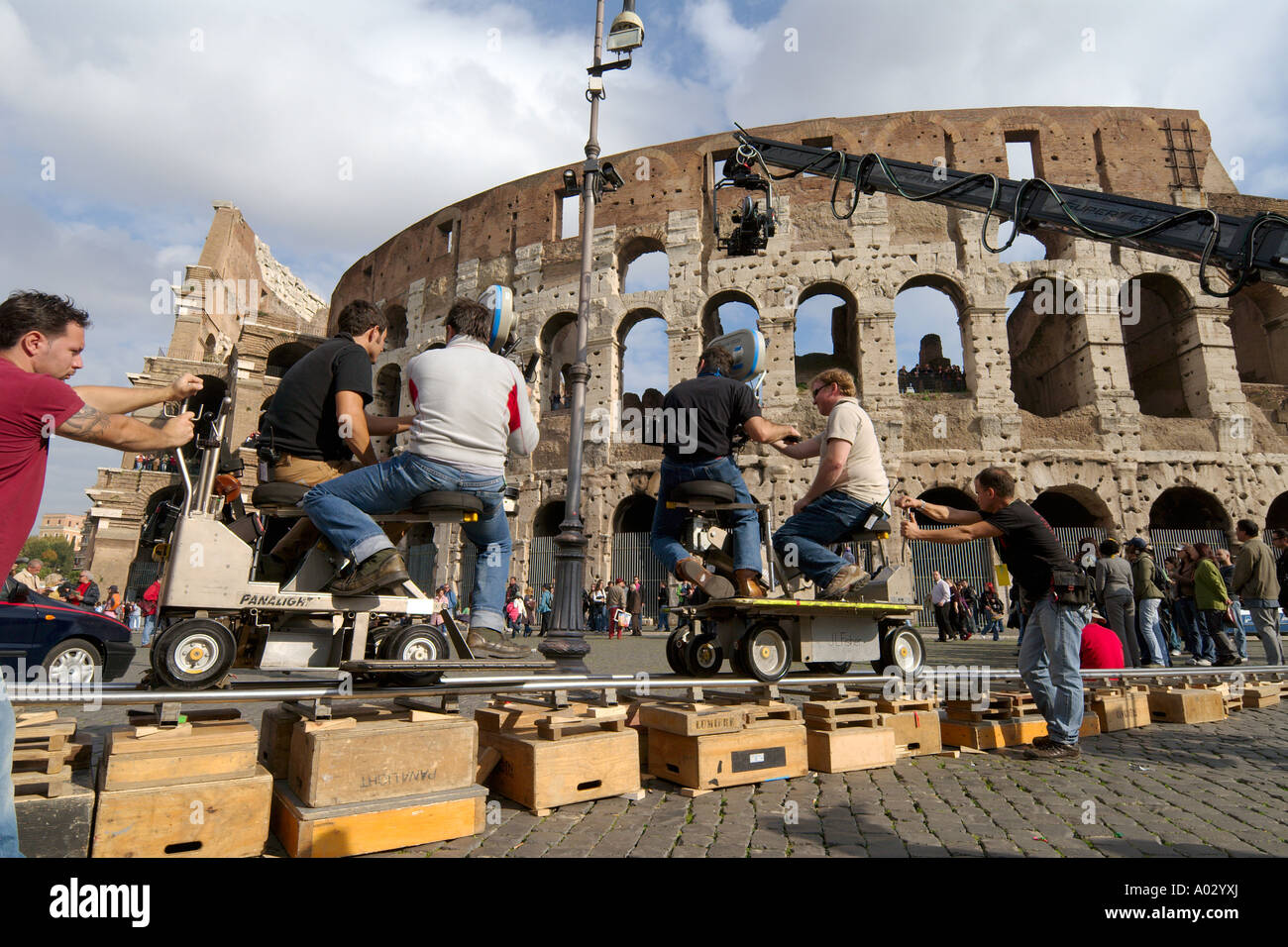 Rome Italy Feature film crew at work on location at the Colosseum using dolly tracks remote controlled telescopic crane Stock Photo