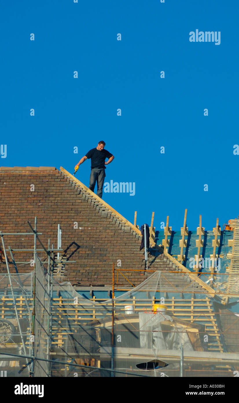 Roofer taking a break to consider his work Stock Photo