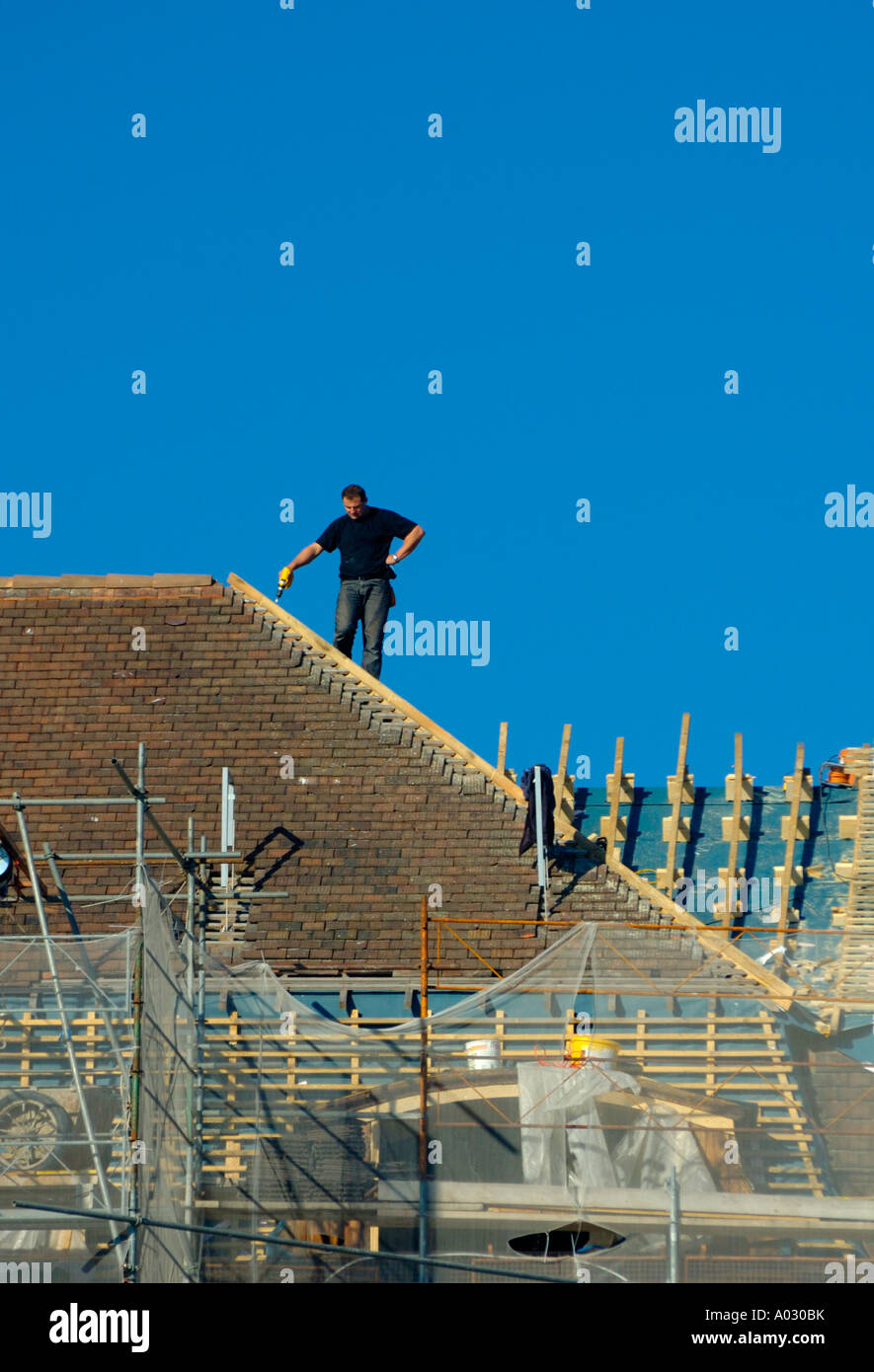 Roofer taking a break to consider his work Stock Photo