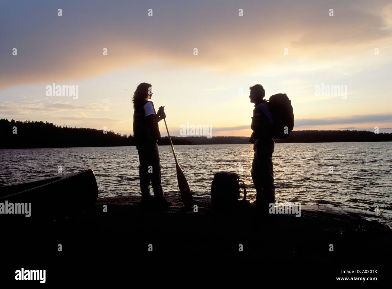 Couple at dusk, Diamond Lake, Lady Evelyn Smoothwater Wilderness Park, Temagami Region, Ontario, Canada.  Rights Protected. Stock Photo