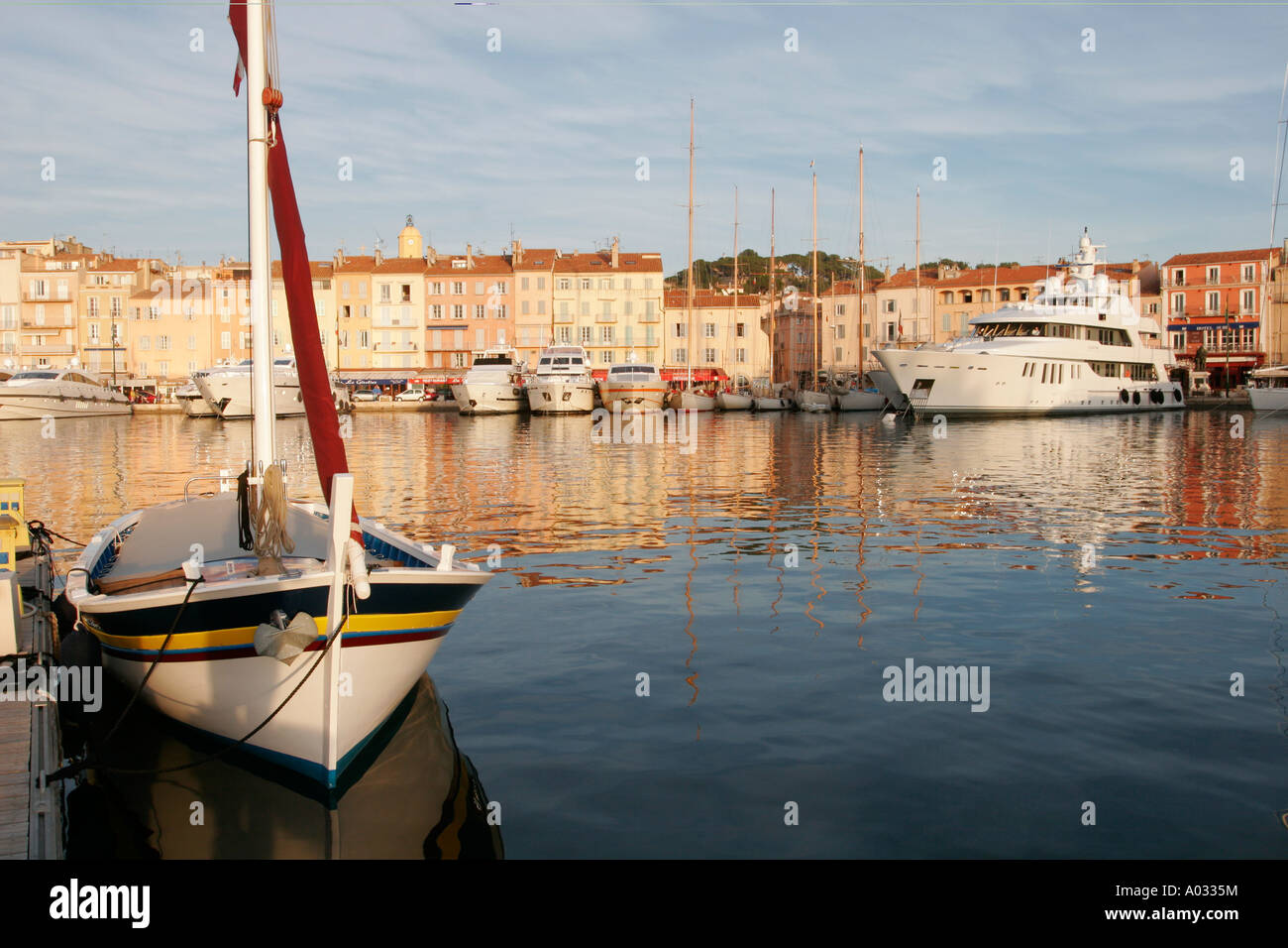 St Tropez Old Port, South of France with Fishing Boat in Foreground Stock Photo