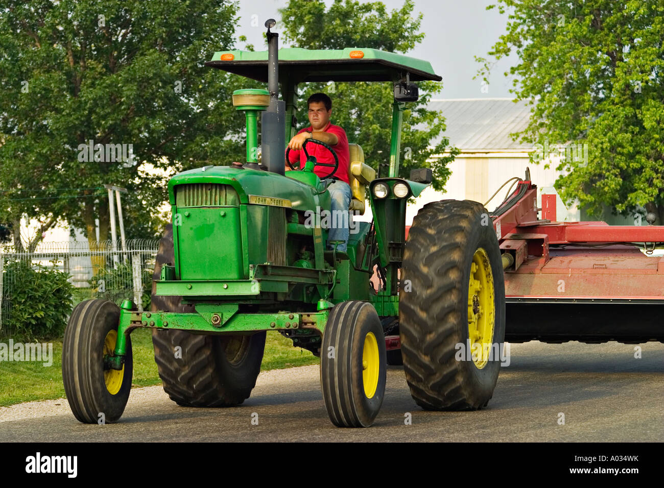 ILLINOIS Arthur Young adult male drive John Deere tractor on road Stock