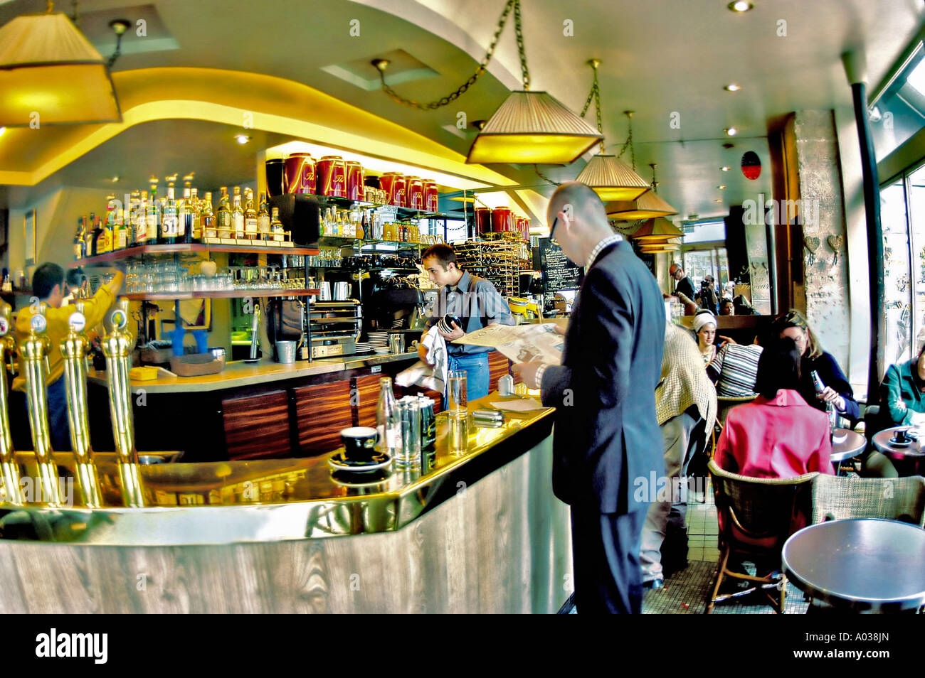PARIS, France, Man Reading Newspaper at the Bar in a Traditional Café, French Bistro Restaurant' 'Le Varenne' Pub Counter, inside bar lights Stock Photo