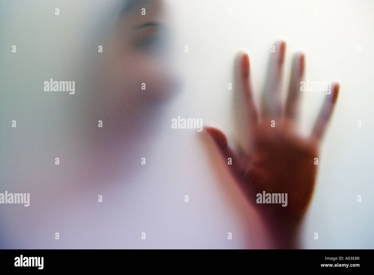 Shadowy ghostly figure of a young asian woman with face and hand held up Stock Photo