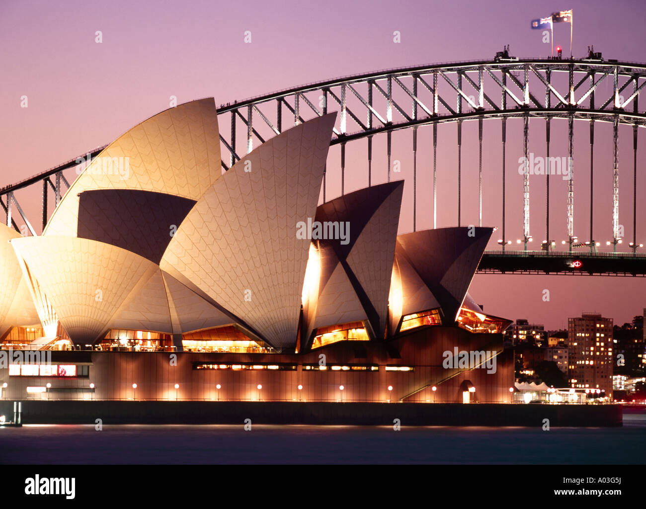 the sydney opera house and the harbour bridge lit up at sunset Stock ...
