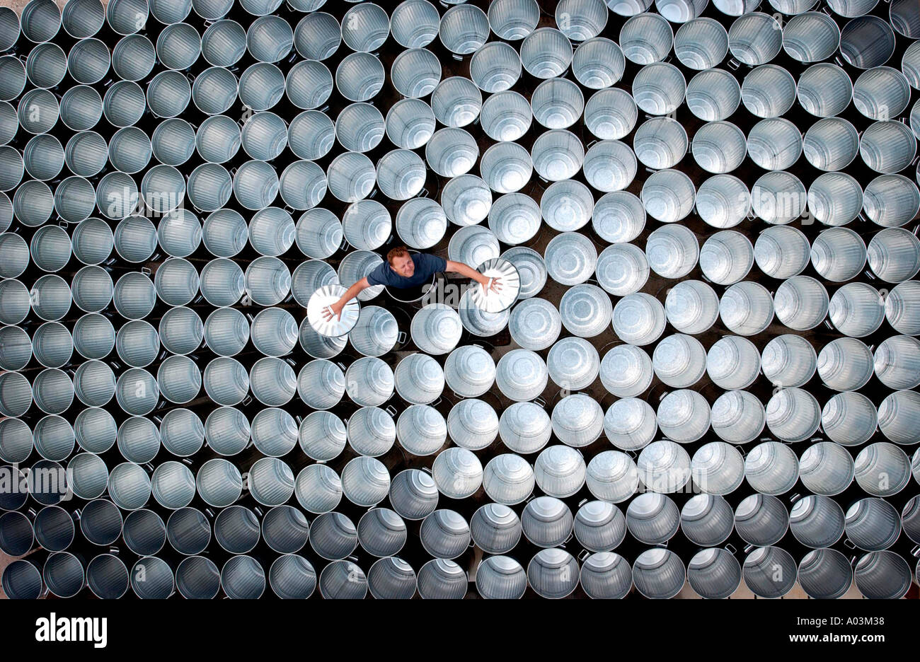 Stomp star Luke Cresswell and gleaming galvanised bins used to make percussion music on stage. Stock Photo