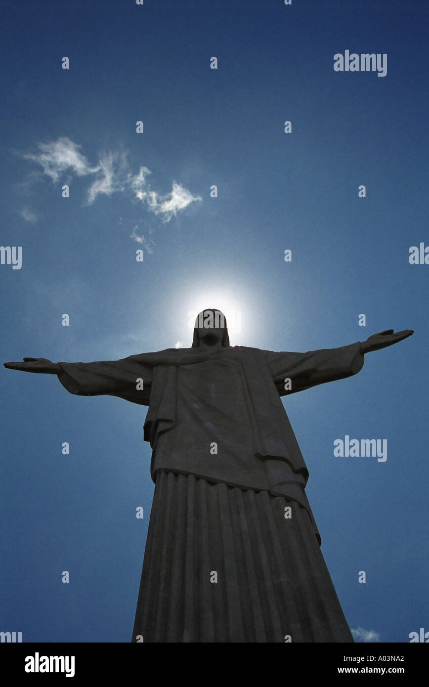 Statue of Christ the Redeemer Rio De Janeiro with the sun causing a halo effect from behind his head Brazil South America Stock Photo