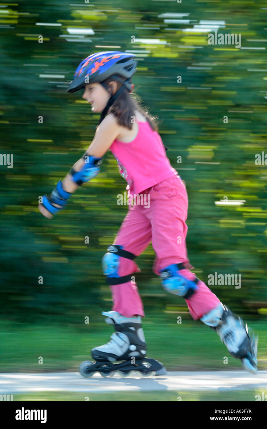 a young girl skating with pads and helmet Stock Photo