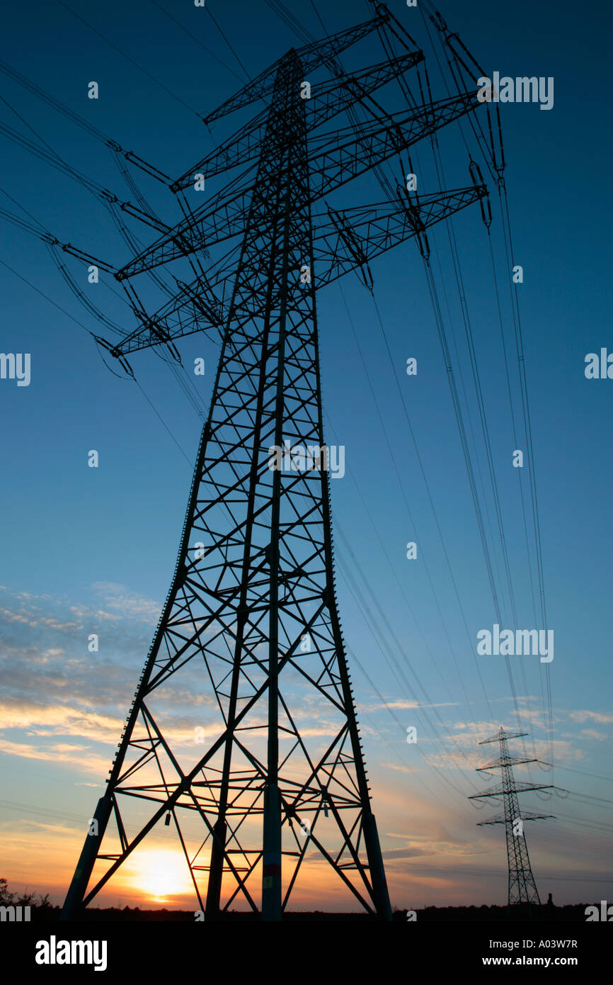 the sun setting behind a power pole Stock Photo