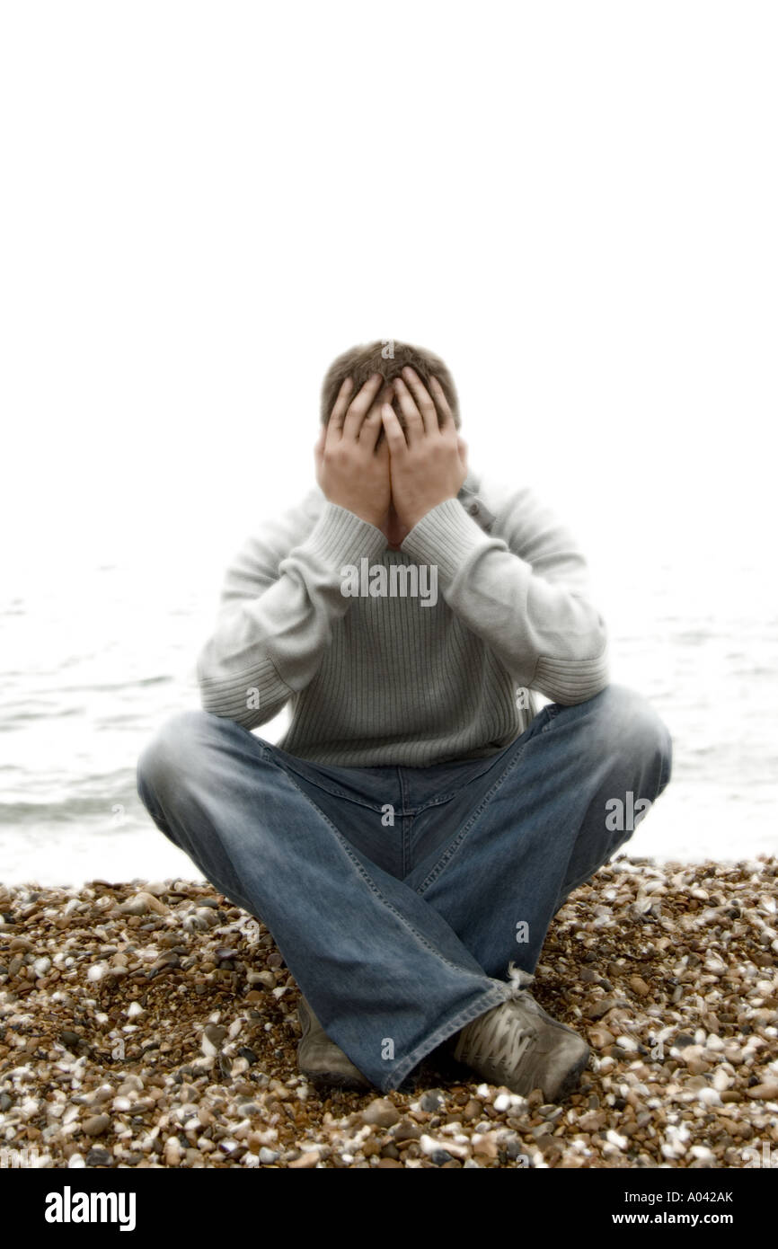 young man with his head in his hands Stock Photo