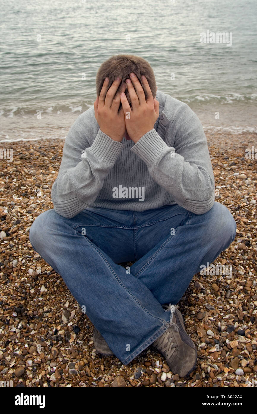 young man with his head in his hands Stock Photo