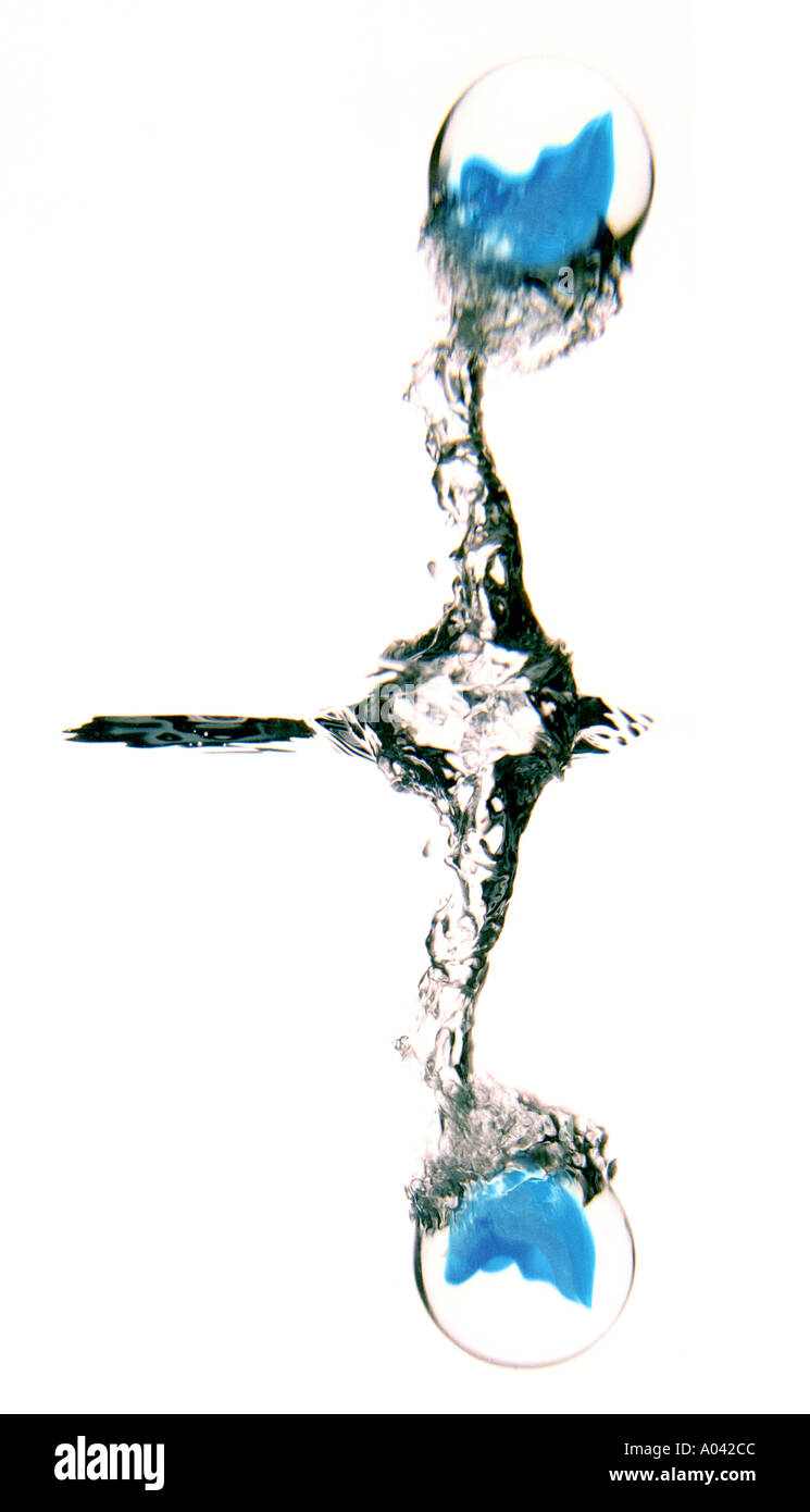 Blue marble splashing into water including reflection, white background Stock Photo