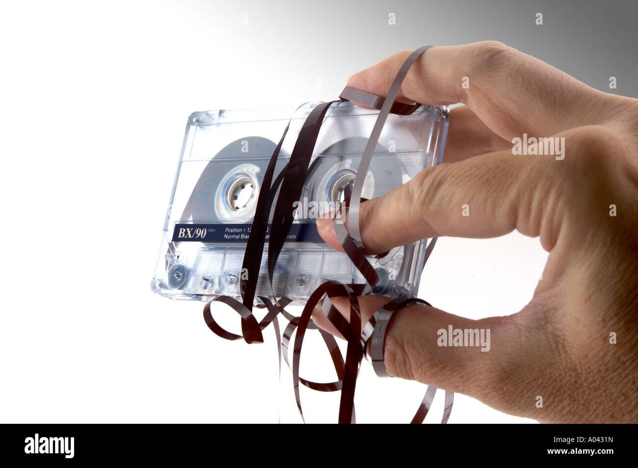 close up of a hand with a compact cassette with tangled tape Stock Photo